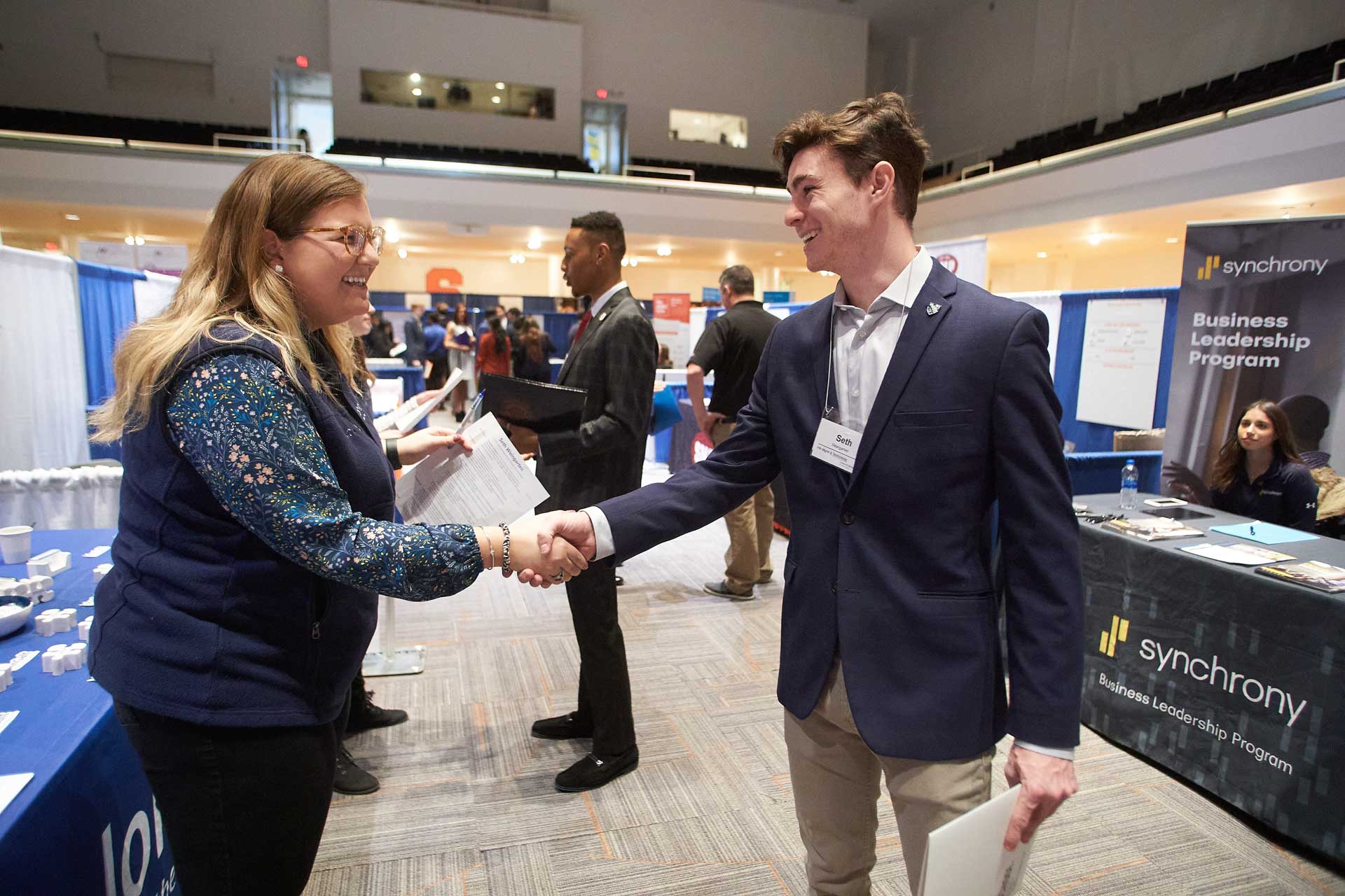 A student and a recruiter shake hands