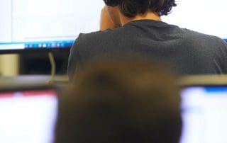 Students working in an iSchool lab's dual-monitor setup