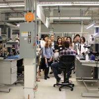 Students listening to employee at lab