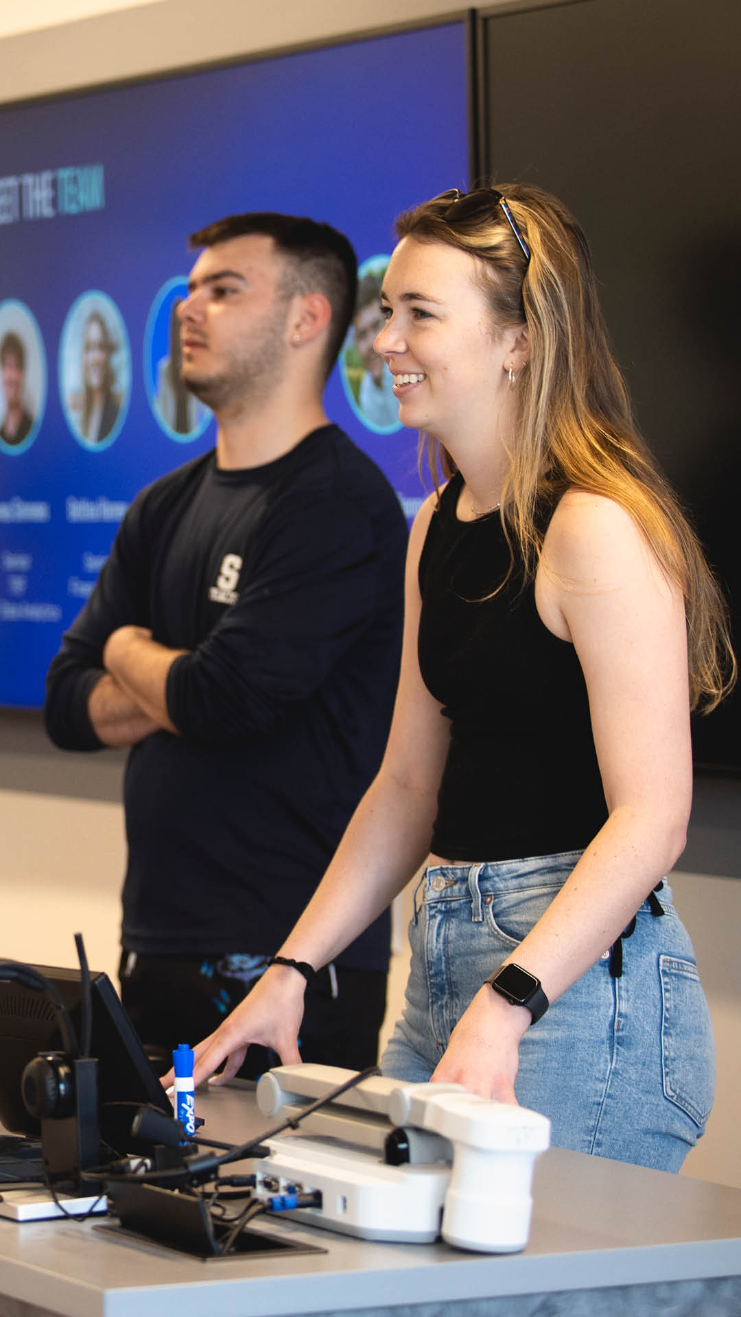 Students presenting and smiling at the front of a classroom