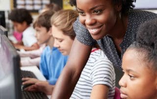 Diverse young woman teaching girls to code